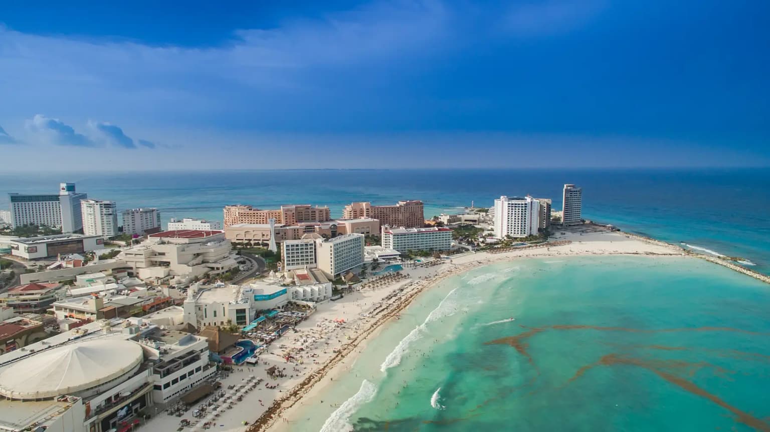 Aerial view of Cancún's Hotel Zone hotels and a curved white beach with shallow turquoise water