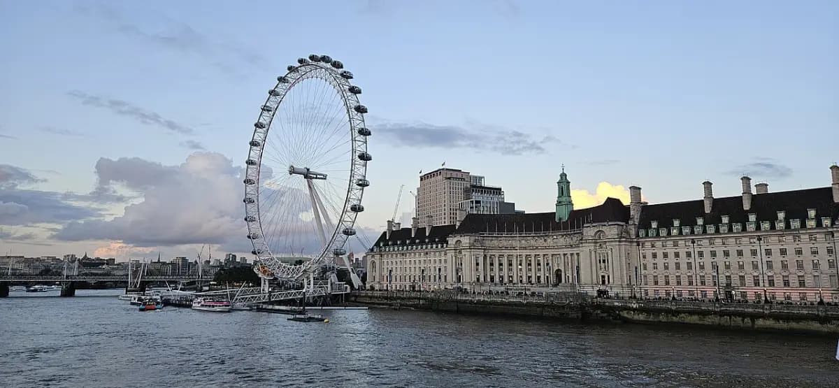 County Hall's long riverside facade and the London Eye beside the Thames at dusk.