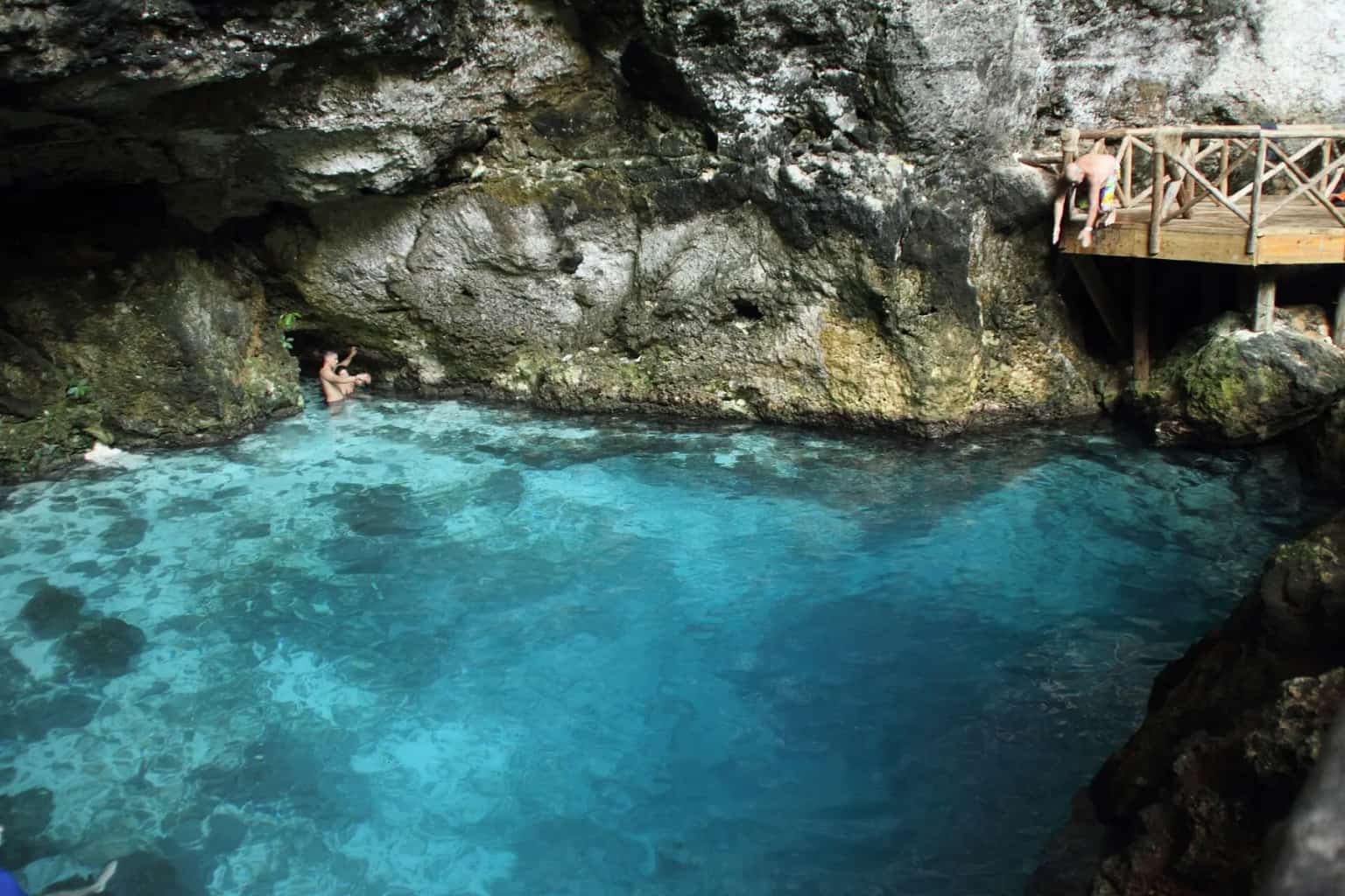 The turquoise Hoyo Azul cenote under a cliff