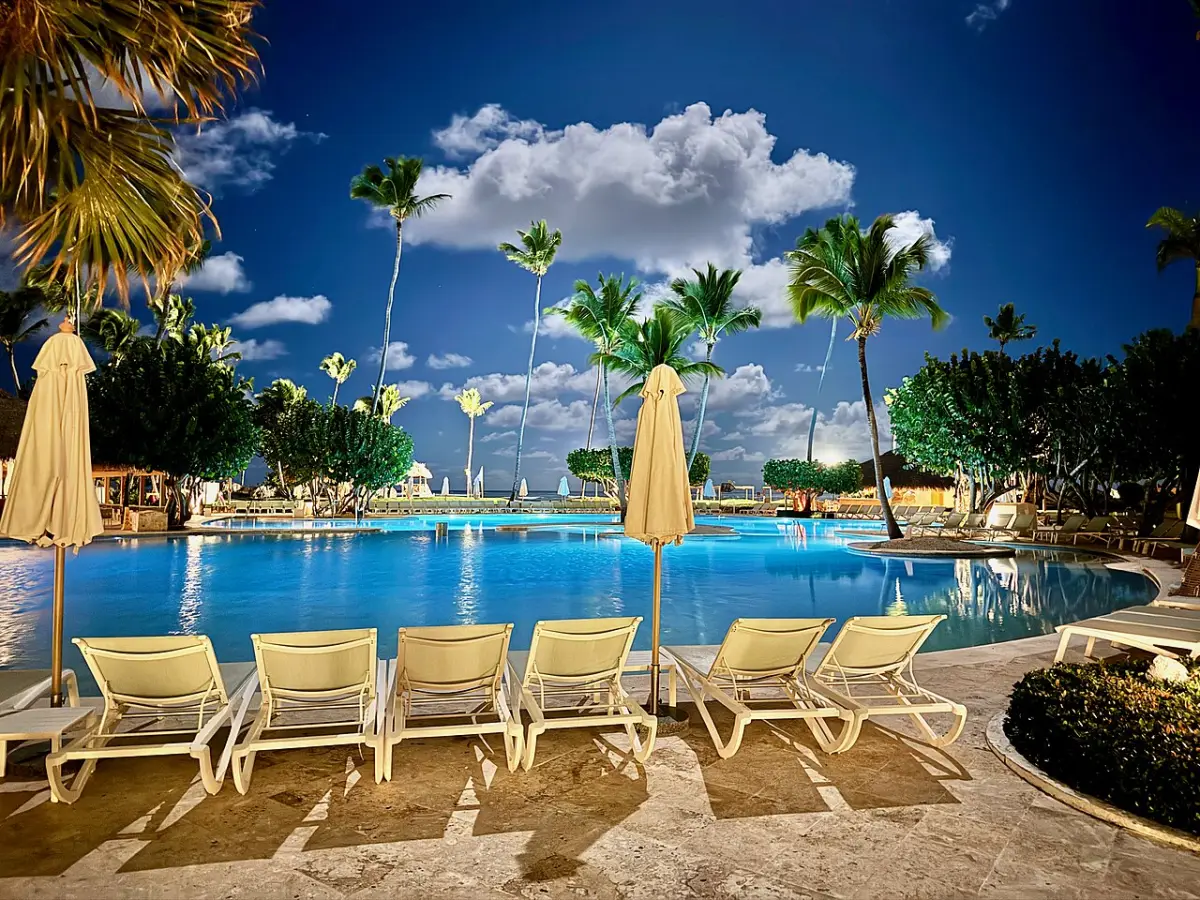 Pool with loungers and umbrellas under palms at Iberostar Selection Bávaro Suites