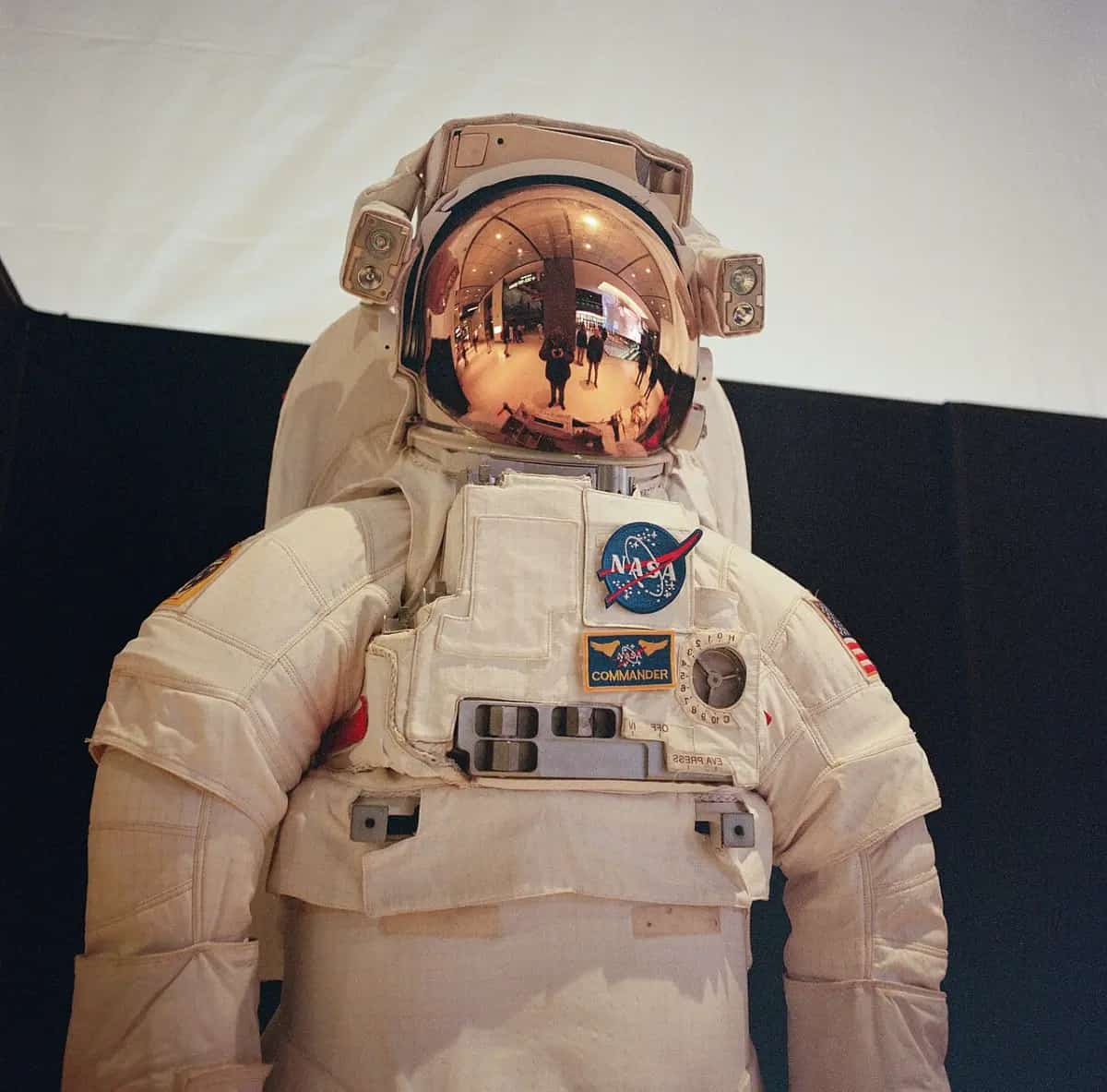 A white NASA spacesuit with a gold reflective visor on display at the National Air and Space Museum.