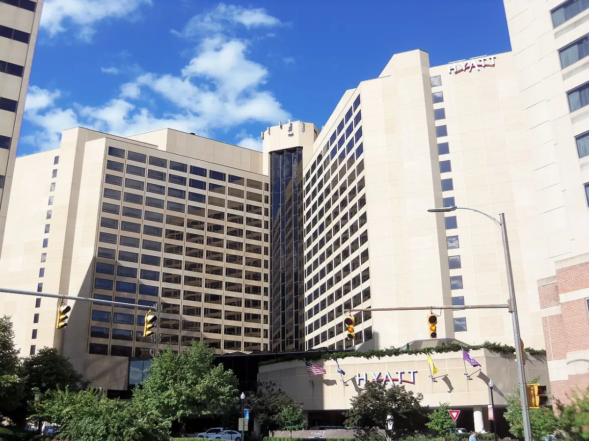 The pale stone towers of the Hyatt Regency Crystal City above its street entrance and Hyatt sign under a blue sky.